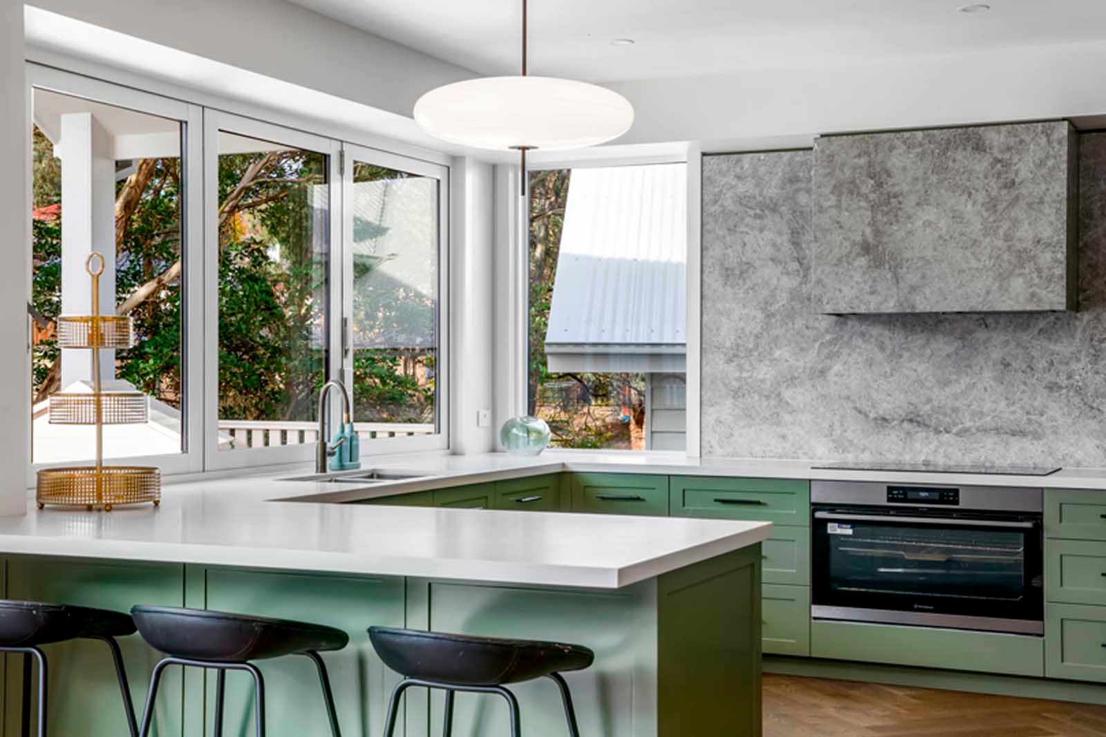 Kitchen with green joinery and stone benchtops