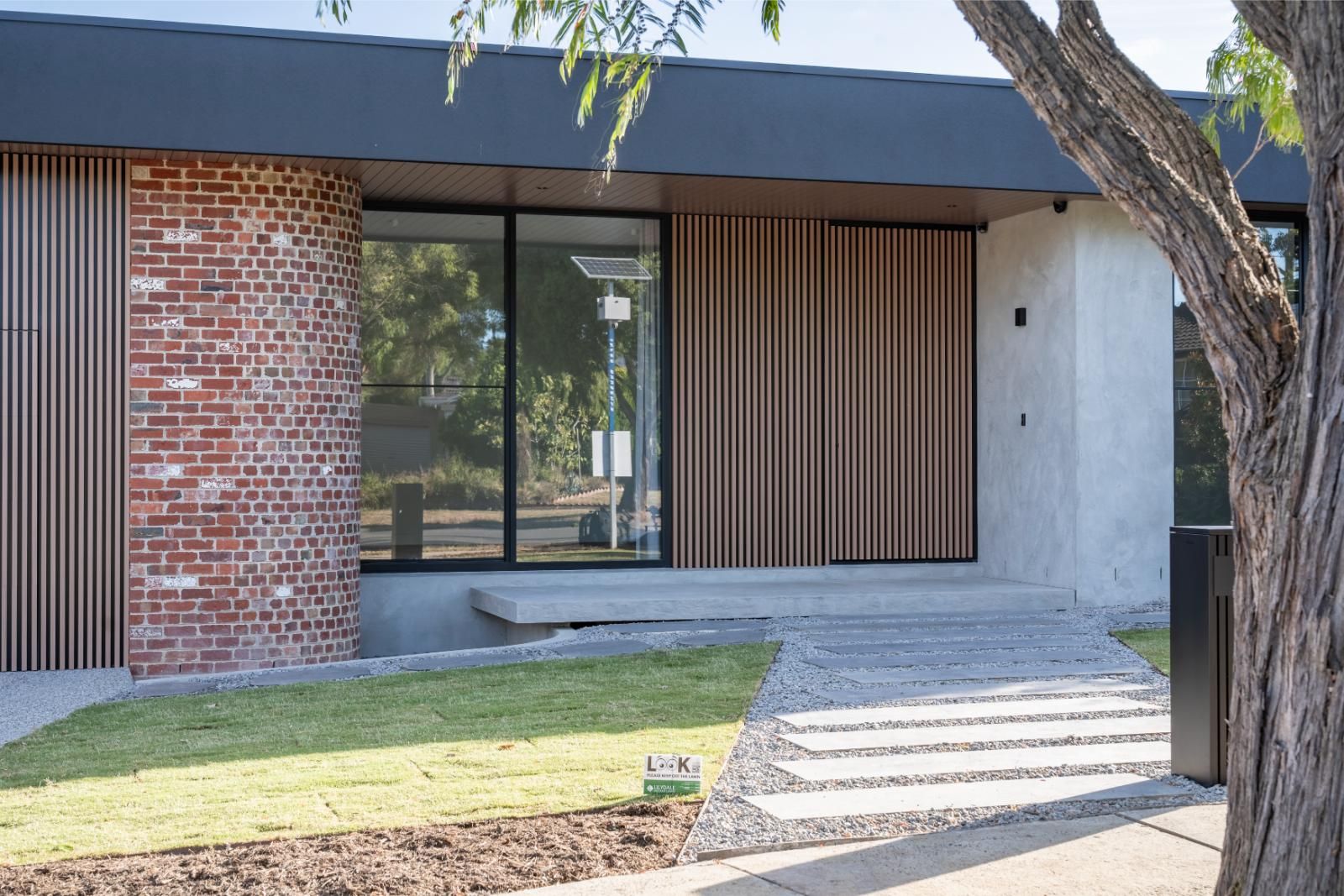 Recycled brick pier and timber-clad wall beside the front entry