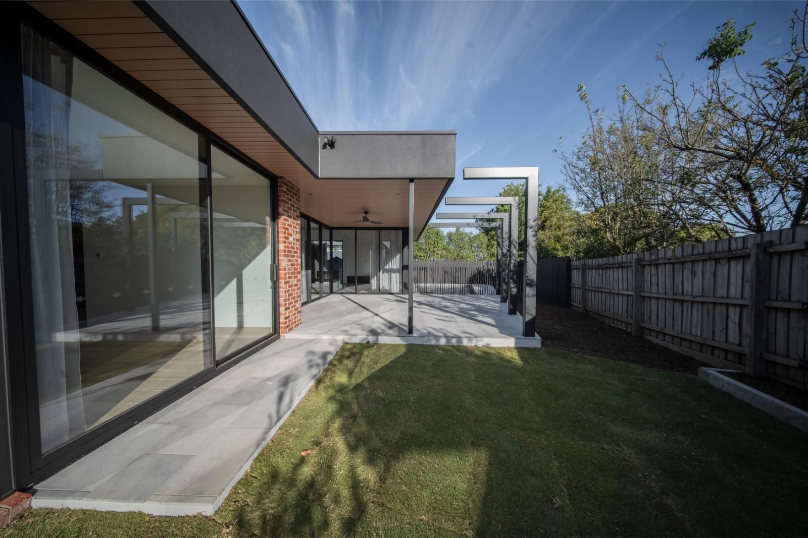 Rear glazing and deep roof overhang looking across the lawn