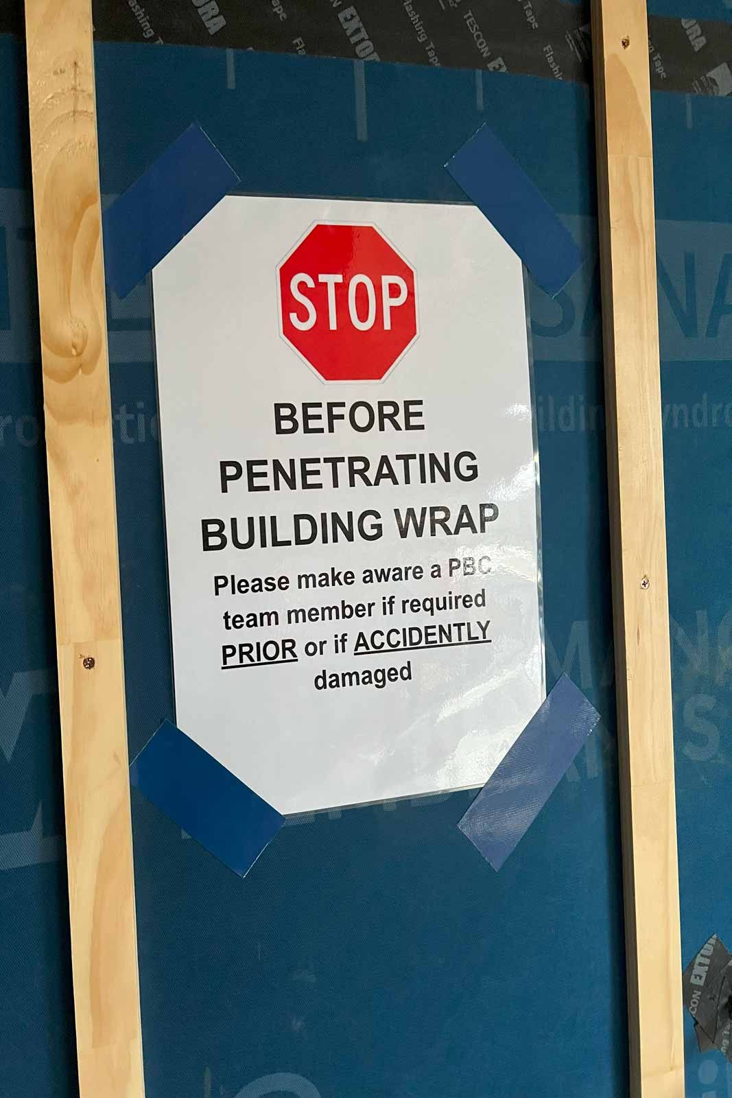Site sign asking trades to check with the Primebuilt team before penetrating the building wrap