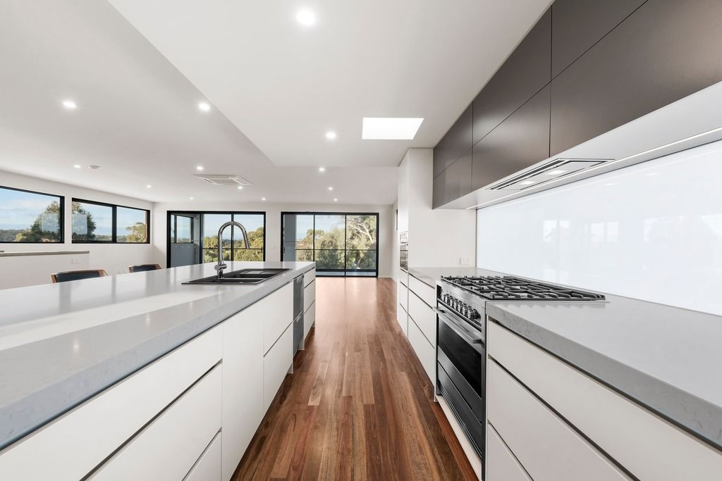 Long kitchen with dark splashback
