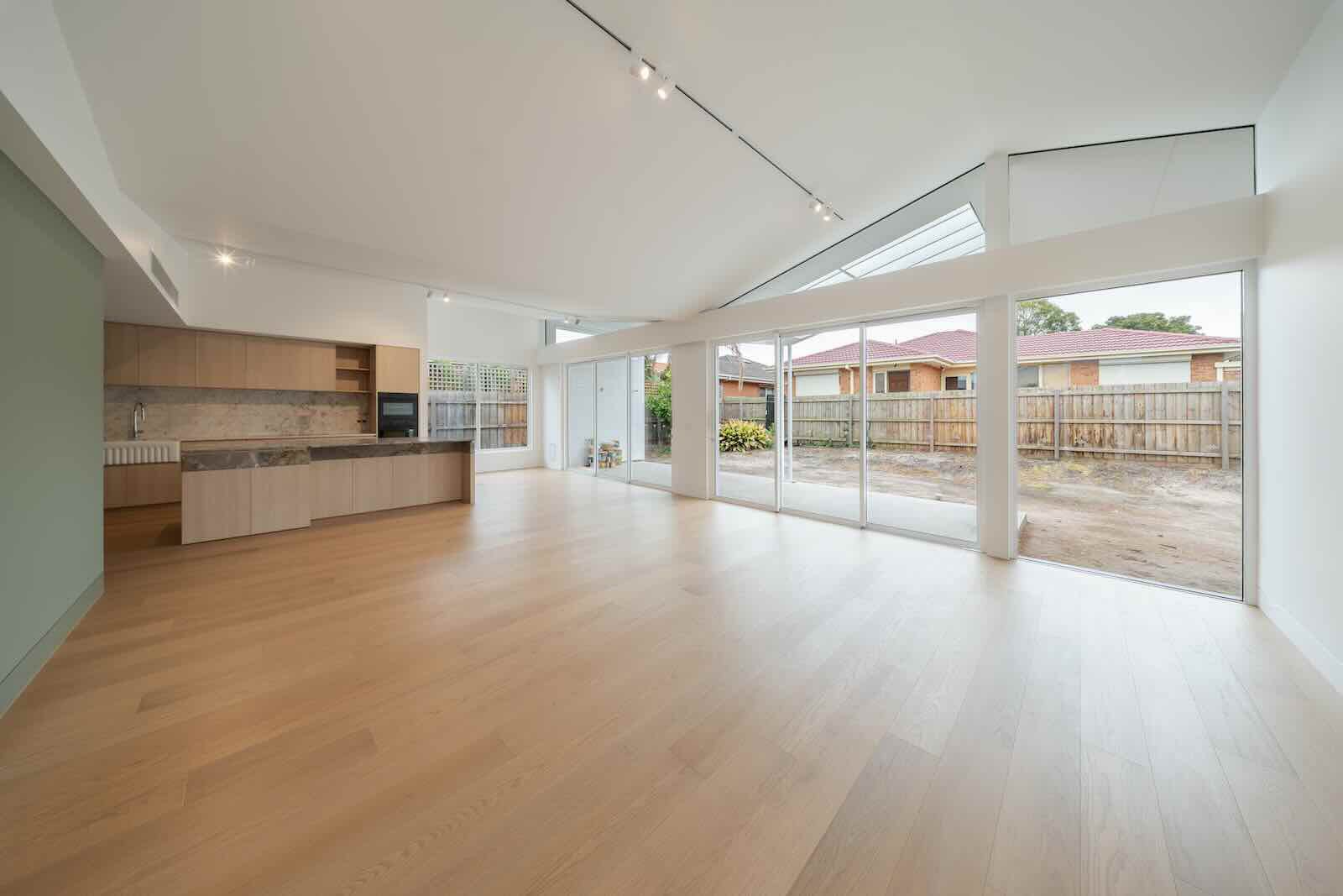 Open-plan living and kitchen in the Glen Huntly extension, with a raked ceiling and wide glazing