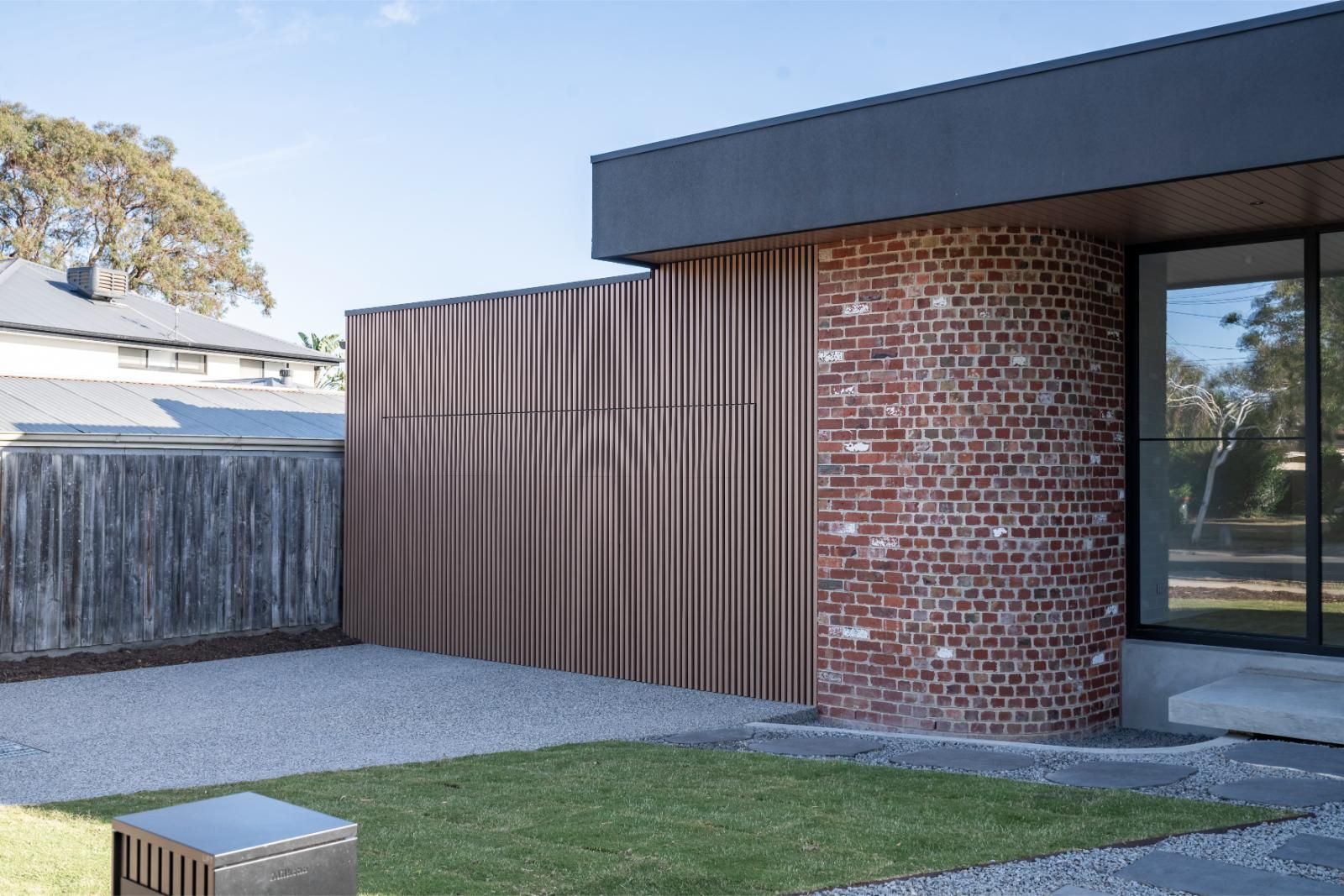 Side view showing the brick, timber cladding and roof overhang