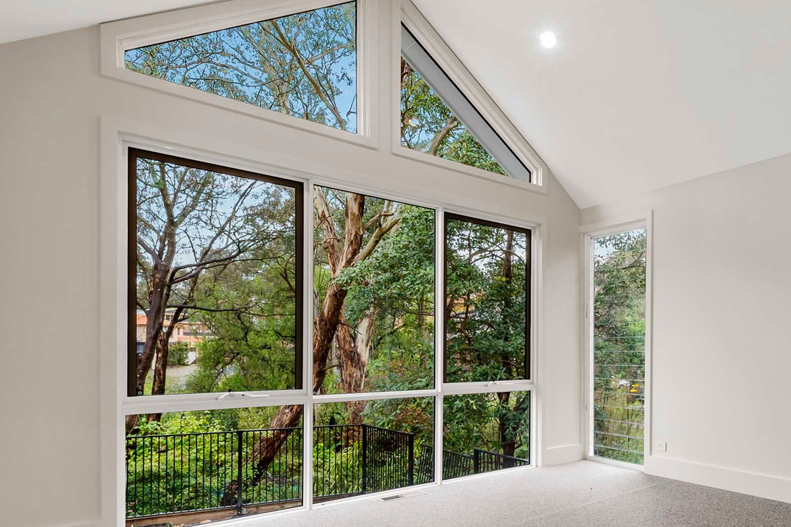 Raked windows framing the gum trees