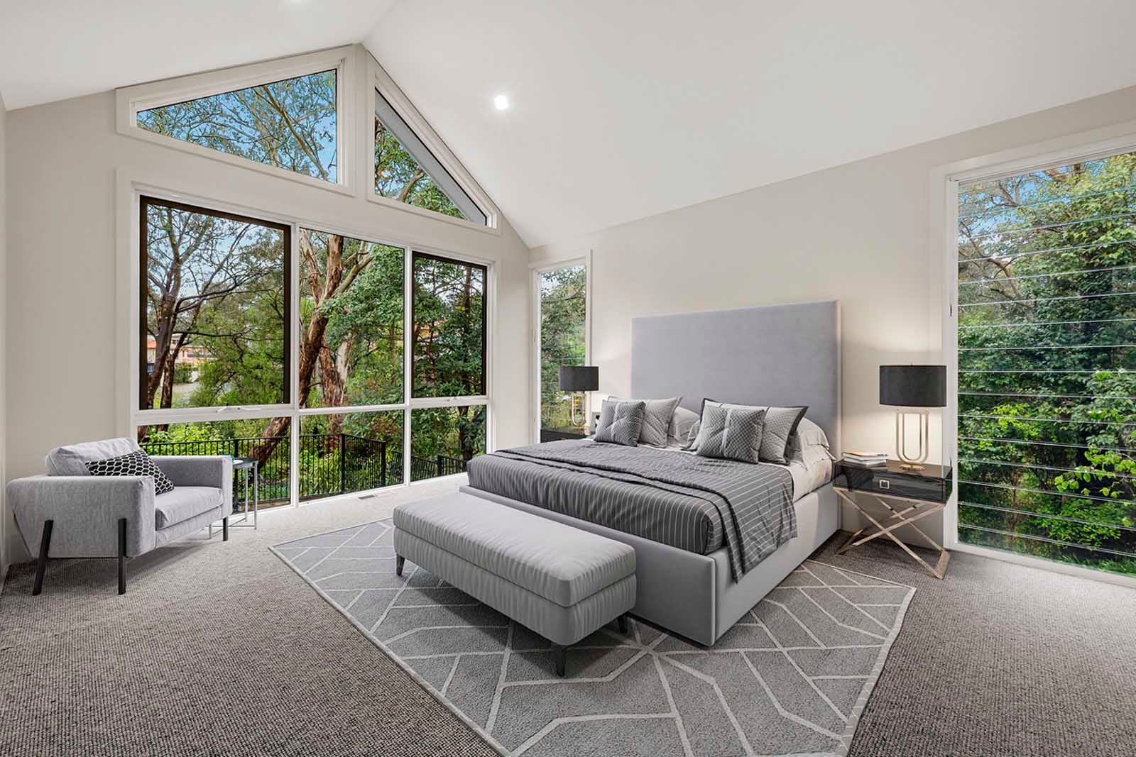 Bedroom with tall windows to the bush