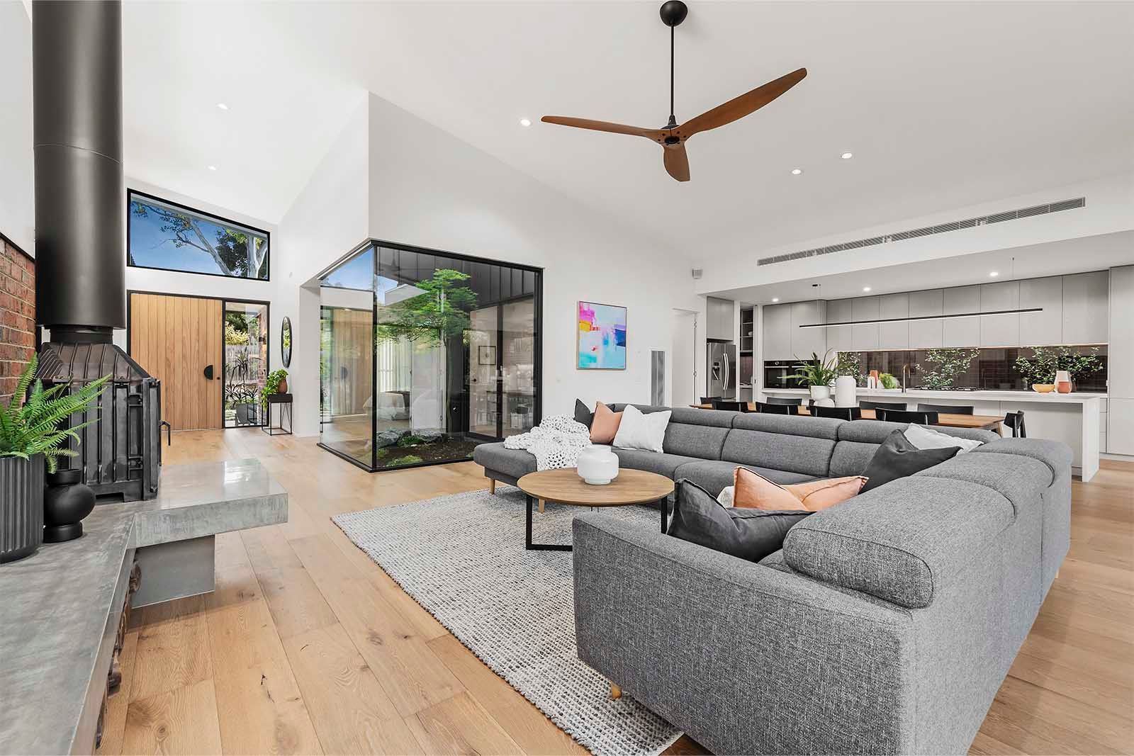Open-plan living with a high raked ceiling and fireplace