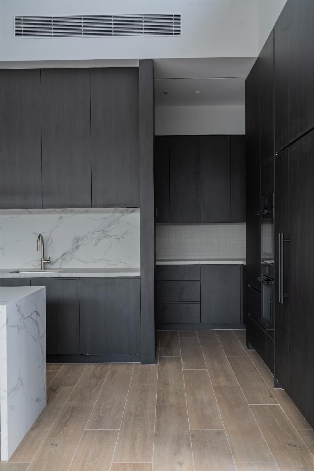 Kitchen and butler’s pantry joinery in dark timber with marble splashback
