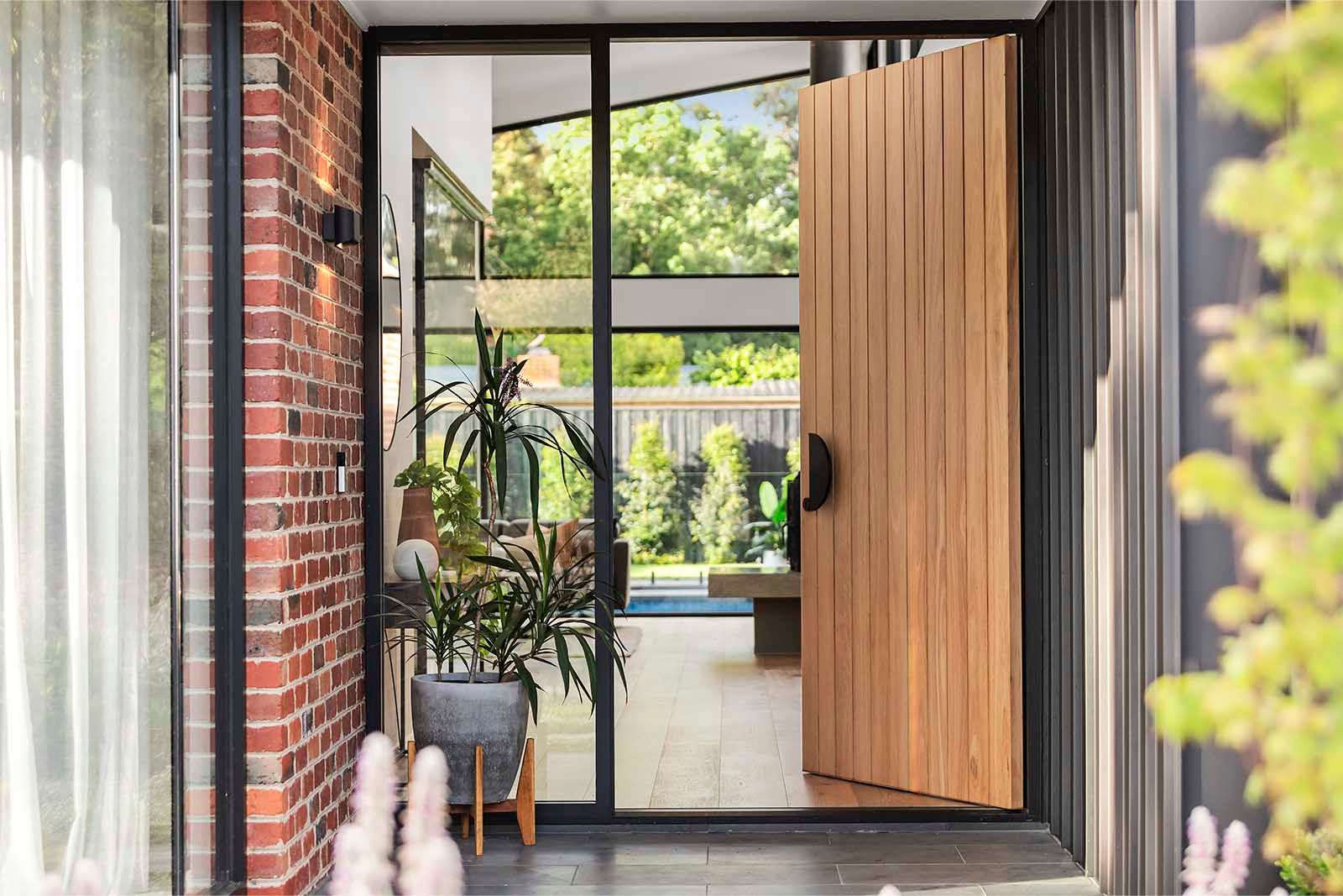 Solid timber front door opening to the glass atrium