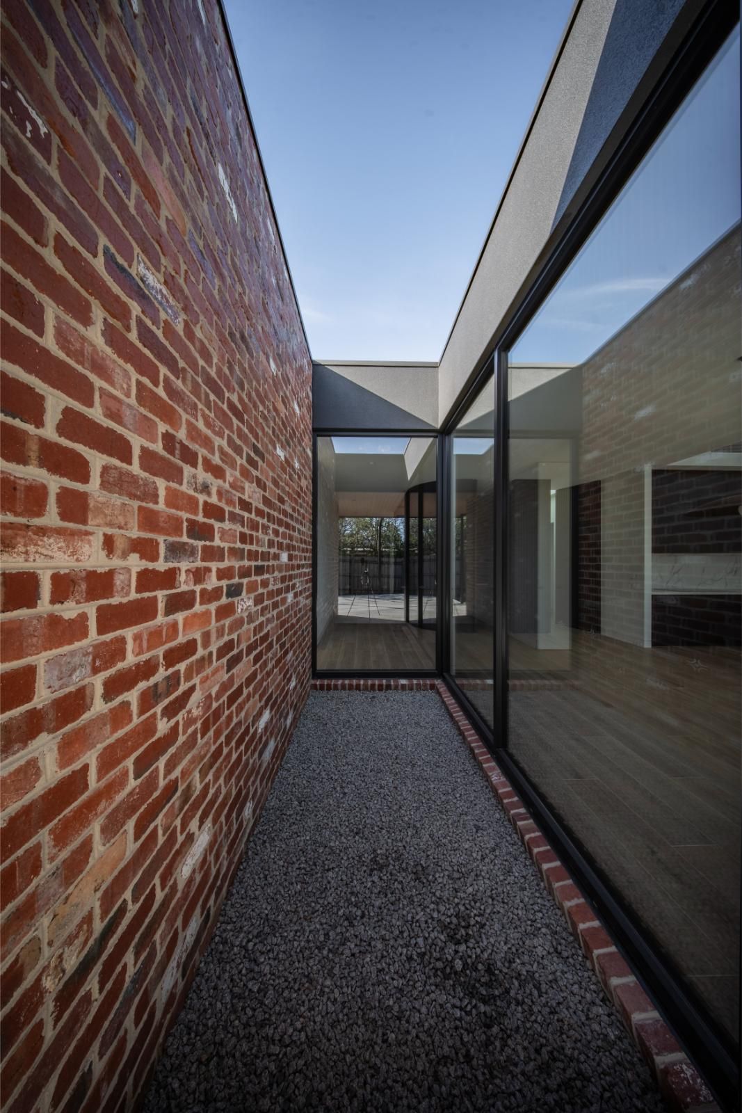 Recycled brick wall running along a glazed hallway