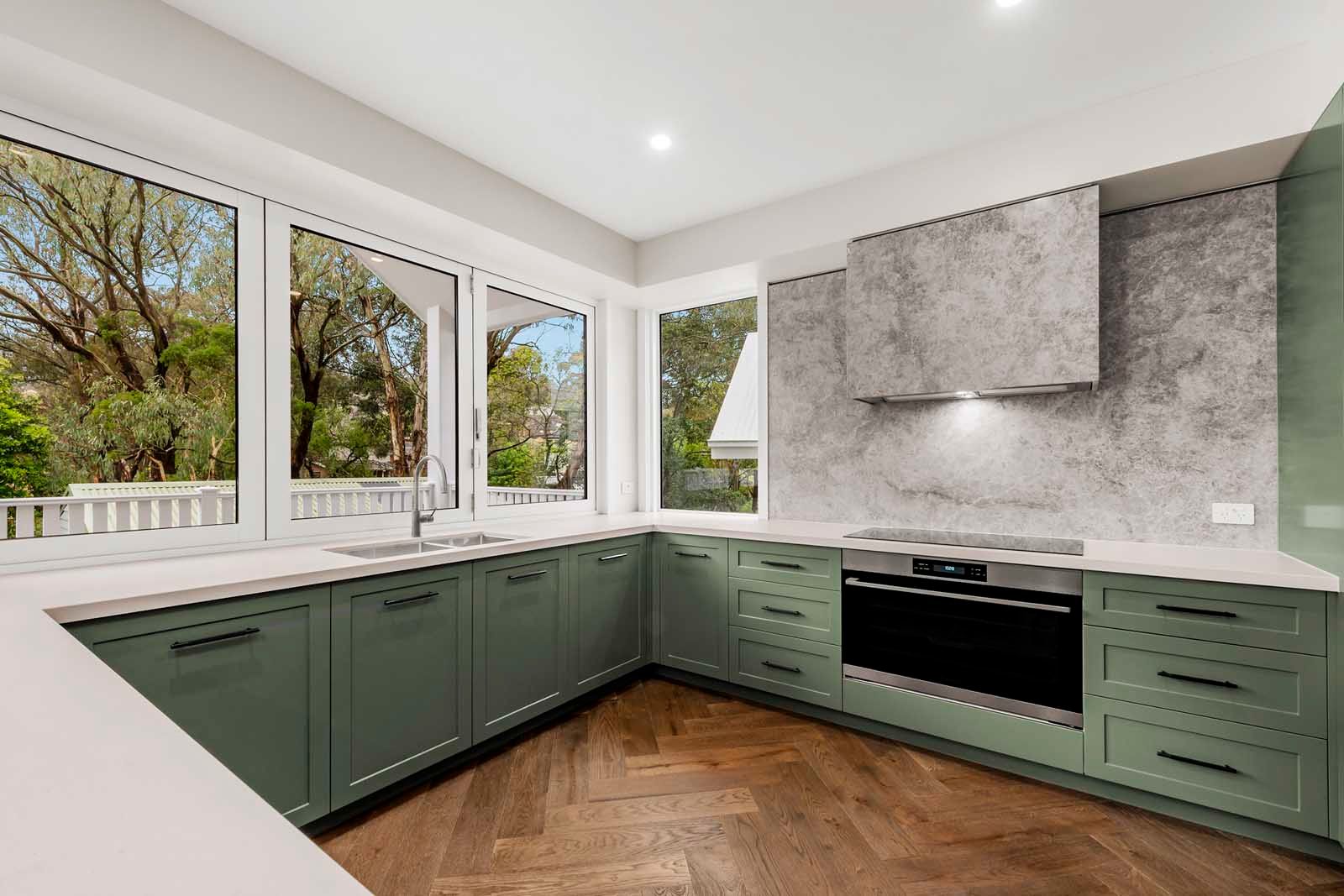 Green kitchen joinery with herringbone floor