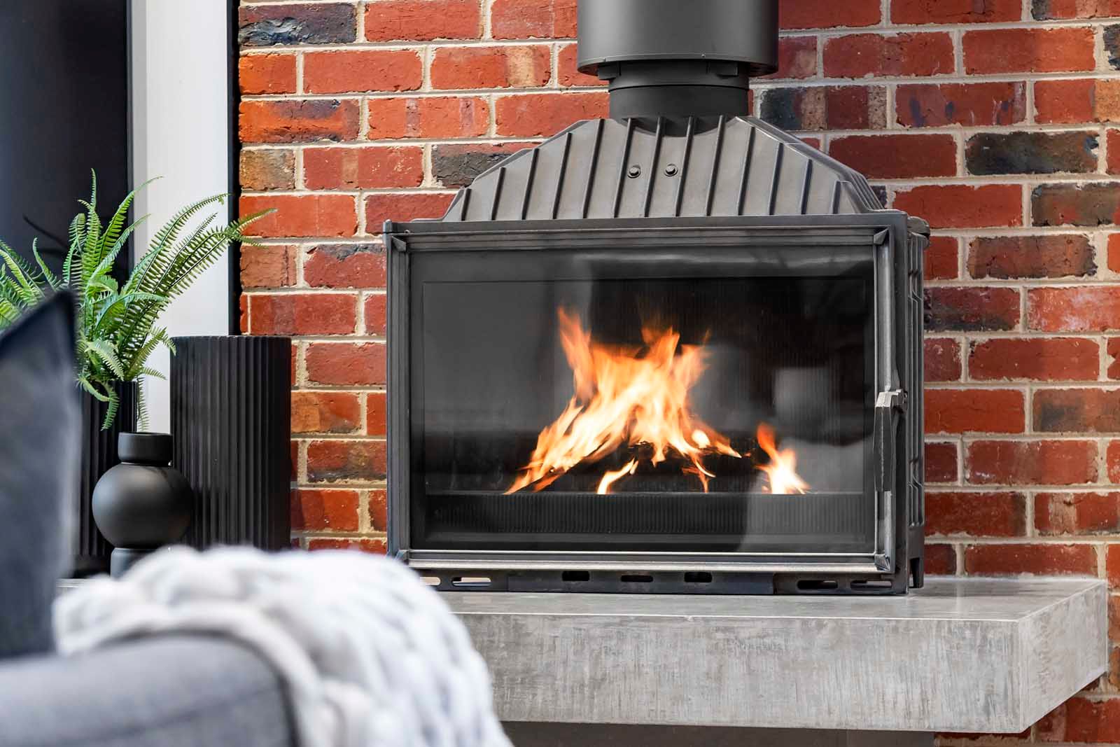 Freestanding fireplace against a recycled brick wall